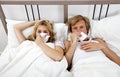 Portrait of couple suffering from cold lying on bed Royalty Free Stock Photo