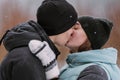 Portrait of couple of teenagers kissing in winter