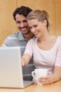 Portrait of a couple using a notebook while having tea Royalty Free Stock Photo