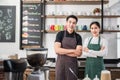 Portrait of couple young barista wearing apron standing smiling with looking at camera in coffee shop