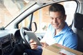 Portrait Of Courier With Digital Tablet In Van Delivering Package To  House Royalty Free Stock Photo