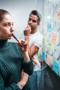 Portrait of coworker people standing at office space behind glass wall with sticky notes Royalty Free Stock Photo