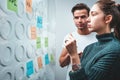 Portrait of coworkers standing at office space behind glass wall with sticky notes Royalty Free Stock Photo