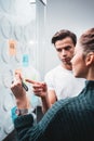 Portrait of coworkers standing at office space behind glass wall with sticky notes Royalty Free Stock Photo