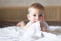 Portrait of a crawling baby on a bed with a blanket in the room Royalty Free Stock Photo