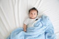 Portrait of a crawling baby on the bed in her room, Adorable baby boy in white sunny bedroom, Newborn child relaxing in bed Royalty Free Stock Photo