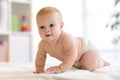 Portrait of a crawling baby on the bed in nursery room Royalty Free Stock Photo