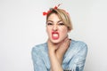 Portrait of crazy angry young woman in casual blue denim shirt with makeup and red headband standing, choke sheself and clenching