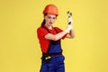 Crazy builder woman holding adjustable wrench, looking at camera with excited facial expression.