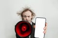 Portrait of crazy businessman holding loudspeaker and smartphone with blank empty white screen display on white background