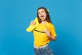Portrait of crazy funny young woman in vivid casual clothes hold yellow skateboard showing tongue, horns up gesture Royalty Free Stock Photo