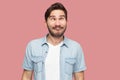 Portrait of crazy handsome bearded young man in blue casual style shirt standing with crossed eyes and looking with funny comedian Royalty Free Stock Photo