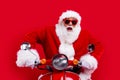 Portrait of crazy impressed santa claus drive fast bike hurry new year time isolated on bright red color background