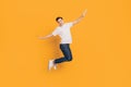 Portrait of crazy inspired guy jump make plan figure hands wings on yellow background