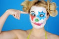 Portrait of a crazy silly female clown with colorful make up wearing bikini in studio
