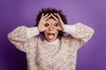 Portrait of crazy young woman showing binoculars open mouth isolated on purple background Royalty Free Stock Photo