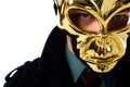 portrait of criminal in golden mask and black coat looking at camera