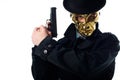 portrait of criminal in golden mask hat and black coat with gun in hands looking at camera