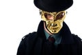 portrait of criminal in golden mask hat and black coat looking at camera