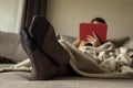 A portrait of crossed feet in pantyhose of a woman relaxing using her tablet