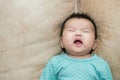 Portrait of a crying baby girl on a leather backgr Royalty Free Stock Photo