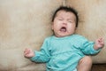 Portrait of a crying baby girl on a leather backgr Royalty Free Stock Photo