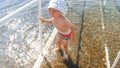 Portrait of crying little boy standing in cold sea water