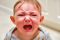 Portrait of a crying toddler baby boy. The face of an unhappy child with tears in his eyes, close-up Royalty Free Stock Photo