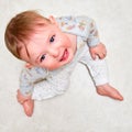 Portrait of a crying toddler boy sitting on the floor. Face of an unhappy child with tears in his eyes, close-up Royalty Free Stock Photo