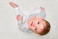 Portrait of a crying toddler boy sitting on the floor. Face of an unhappy child with tears in his eyes, close-up Royalty Free Stock Photo