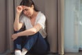 Portrait of a crying woman, clutching her head and sitting on the floor. Copy space. The concept of domestic violence and day of