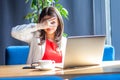 Portrait of cunning beautiful stylish brunette young woman sitting and looking at laptop screen through her fingers. shyness,