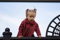 Portrait of curiosity caucasian child of two years old looking down from high point on the blue sky background