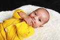 Portrait of curious baby boy lying on back on white fur Royalty Free Stock Photo