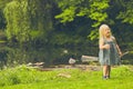 Curious little girl walking at pond in summer