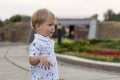 A portrait of a curious or surprised cute baby boy stayibg in the park at summer day. Emotions, grimace, surprise, kid Royalty Free Stock Photo