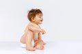 Portrait of curious toddler boy, baby in diaper crawling isolated over white studio background. Playing child Royalty Free Stock Photo