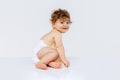 Portrait of curious toddler boy, baby in diaper crawling isolated over white studio background. Playing child Royalty Free Stock Photo