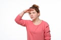 Portrait of a curious young girl looking far away with hand at her forehead, trying to see something far away Royalty Free Stock Photo