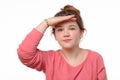 Portrait of a curious young girl looking far away with hand at her forehead, trying to see something far away Royalty Free Stock Photo