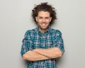 portrait of curly hair man with glasses smiling, looking forward and crossing arms Royalty Free Stock Photo