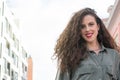 Portrait of curly-haired young woman on the street. Latin woman. Arab woman