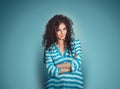 Portrait of curly young gorgeous brunette woman isolated over blue background wall Royalty Free Stock Photo