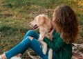 Young woman playing with her dog golden retriever near river at the park Royalty Free Stock Photo