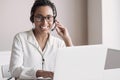 Portrait of customer service assistant talking on phone. Woman wearing headset working on laptop computer. Royalty Free Stock Photo