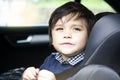 Portrait cut lilttle boy sitting in a car in safety chair, Adorable toddler boy sitting in car seat, Child in car seat with belt o