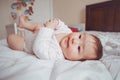 cute adorable Asian mixed race baby girl four months old lying on bed in bedroom. Royalty Free Stock Photo