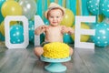 Caucasian baby boy celebrating his first birthday. Cake smash