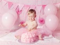 Portrait of cute adorable Caucasian baby girl with blue eyes in pink tutu skirt celebrating her first birthday with gourmet cake Royalty Free Stock Photo