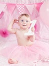 Portrait of cute adorable Caucasian baby girl with blue eyes in pink tutu skirt celebrating her first birthday with gourmet cake Royalty Free Stock Photo